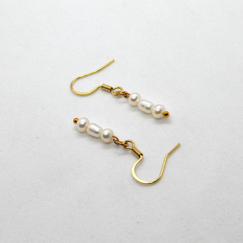 Gold hook earrings with three white faux pearls