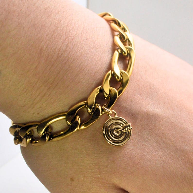 Chunky gold chain bracelet with a heart and bullseye charm