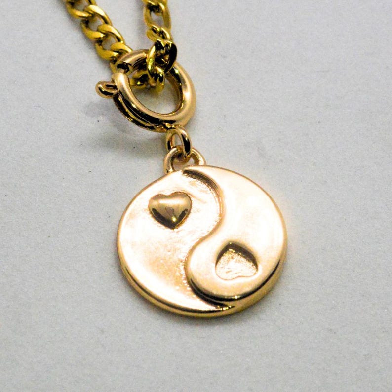 Gold chain necklace with a heart yin yang charm