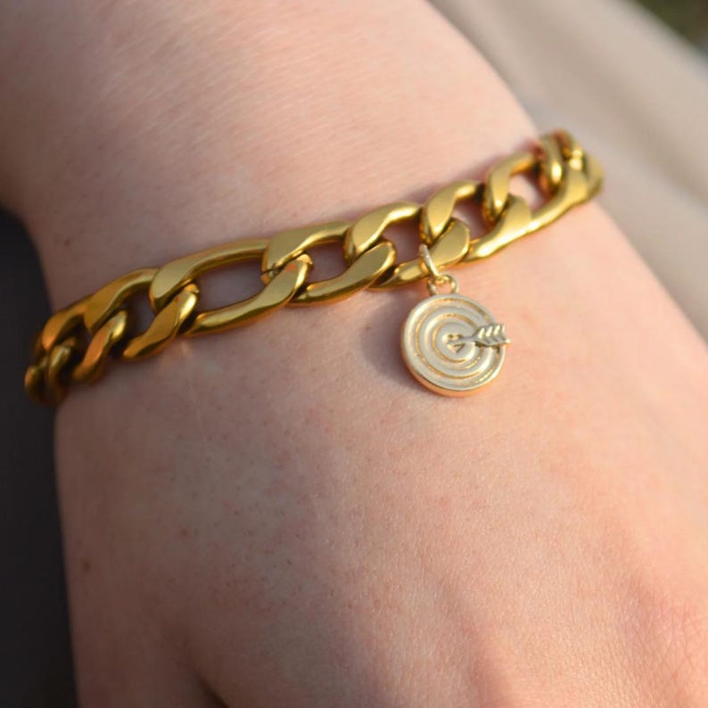 Chunky gold chain bracelet with a heart and bullseye charm