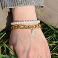 Chunky gold chain bracelet with a heart and bullseye charm