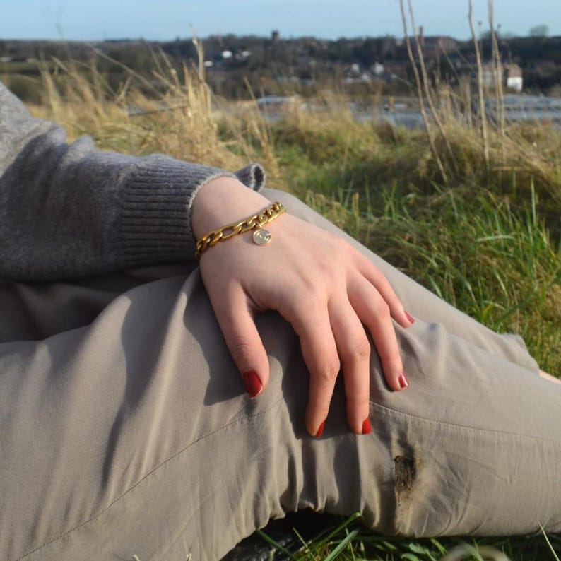Chunky gold chain bracelet worn on a wrist
