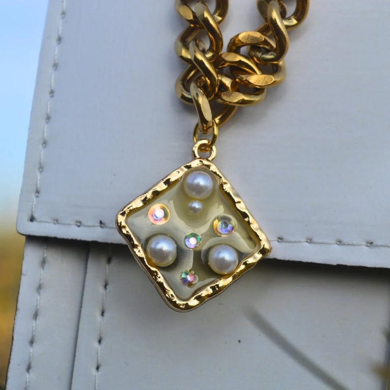 Gold chunky necklace with a square pearl and gem pendant
