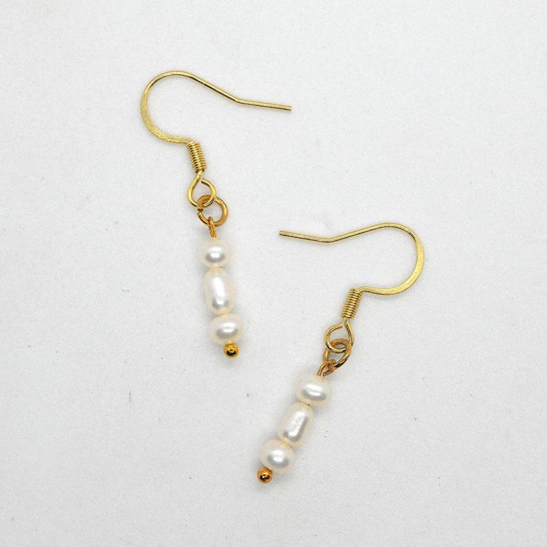 Gold hook earrings with three white faux pearls