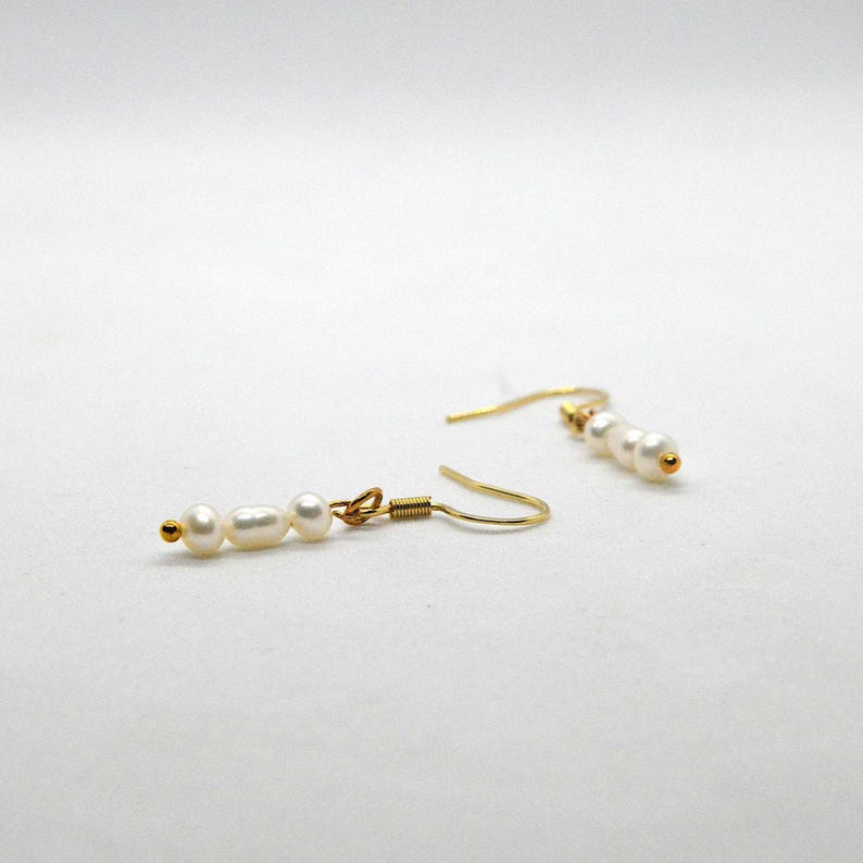 Gold hook earrings with three white faux pearls