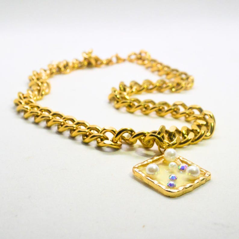 Gold chunky necklace with a square pearl and gem pendant
