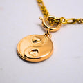 Gold chain necklace with a heart yin yang charm
