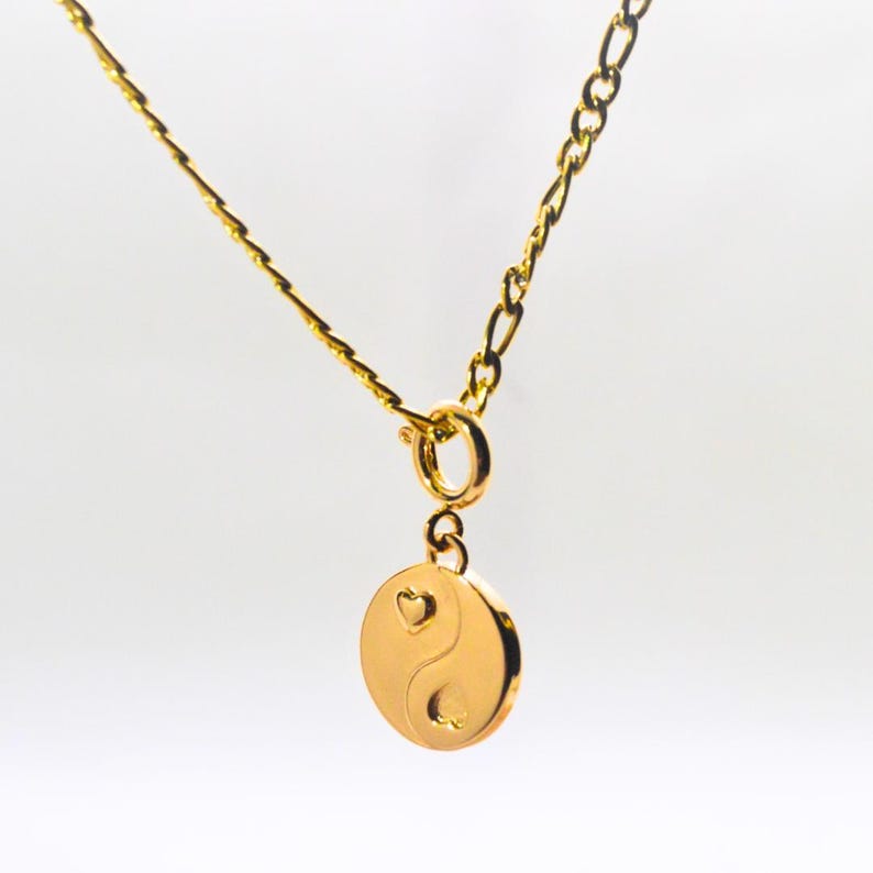 Gold chain necklace with a heart yin yang charm