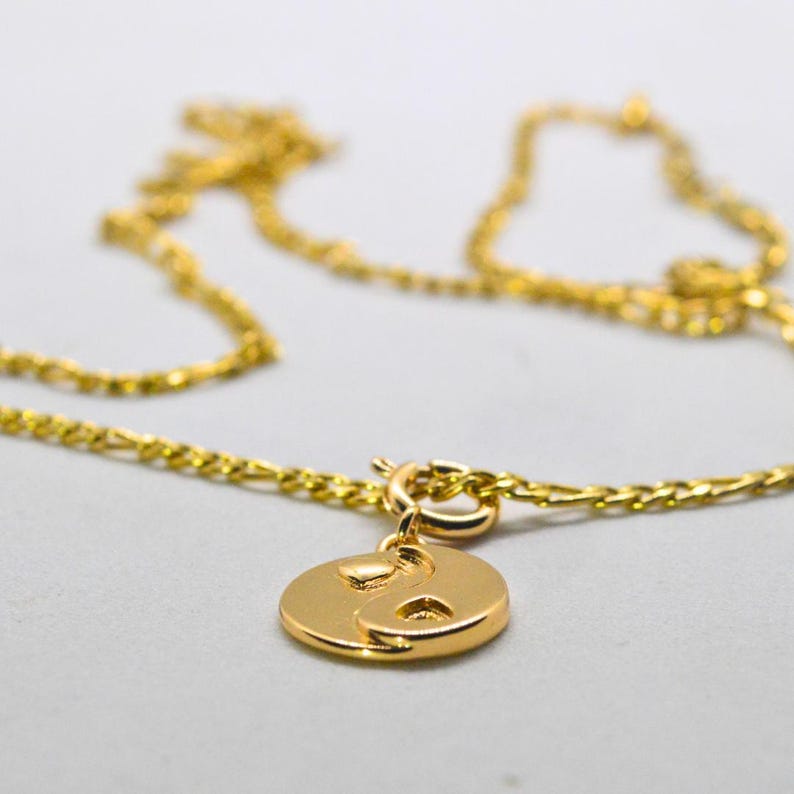 Gold chain necklace with a heart yin yang charm