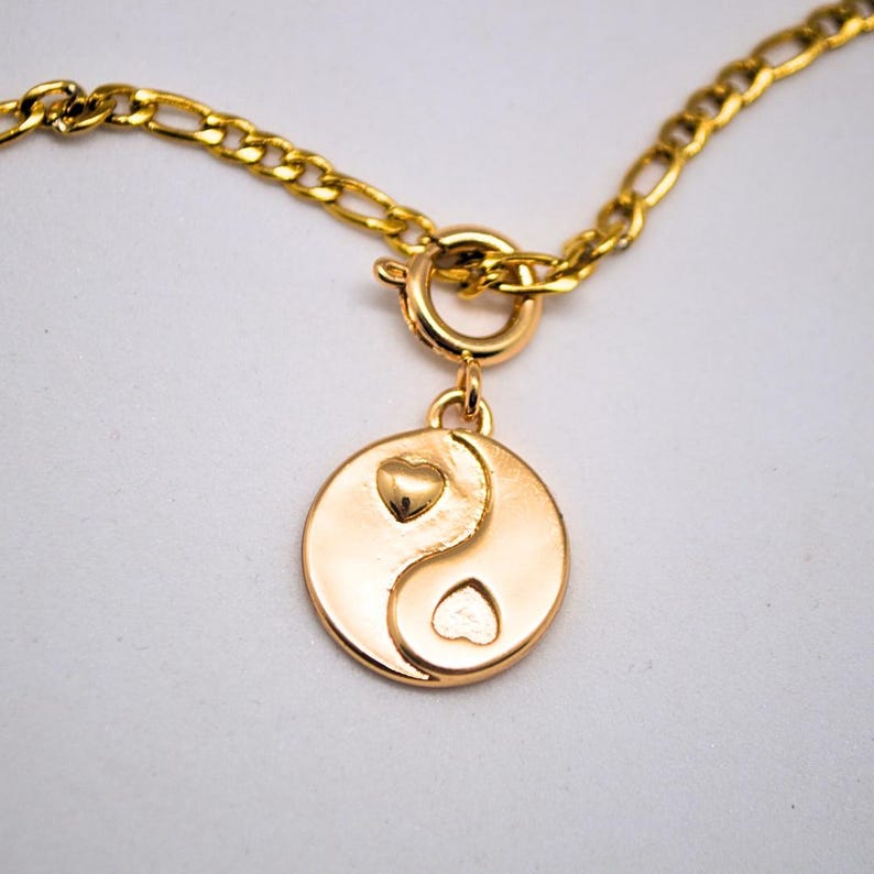 Gold chain necklace with a heart yin yang charm