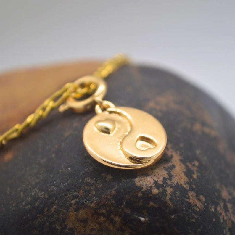 Gold chain necklace with a heart yin yang charm
