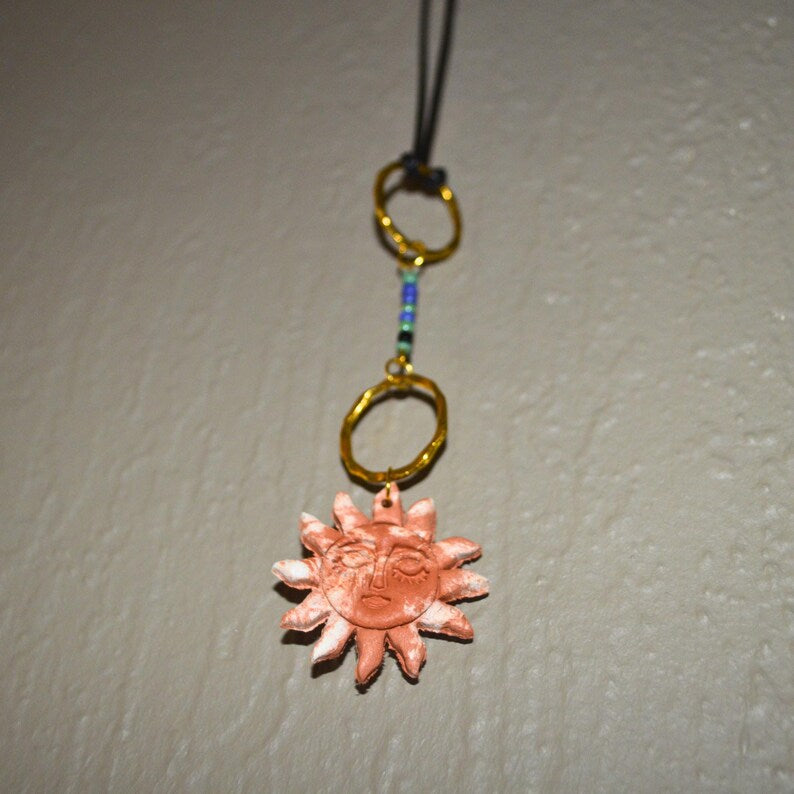 Terracotta clay sun pendant with gold rings and beads